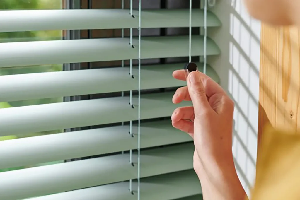 Sustentabilidad 5 Venetian Blinds Close Up Photo woman cord operating green slats crop